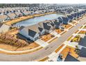 Panoramic aerial view of a residential neighborhood with a tranquil pond, showcasing the community's serene setting at 7375 Sarteano Dr., Myrtle Beach, SC 29572