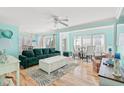 Bright living room features a green sofa, white coffee table, and dining area with sliding glass doors at 908 S Ocean Blvd., North Myrtle Beach, SC 29582