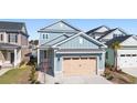 Beautiful two-story home with blue siding, light woodgrain garage door, landscaping, and covered entry for curb appeal at 921 Crystal Water Way, Myrtle Beach, SC 29579