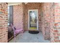 Cozy red brick front porch features a decorative door and a pink metal chair at 951 Foxtail Dr., Longs, SC 29568