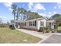 Tan home featuring a cozy front porch, neat landscaping, and a welcoming walkway at 107 Ben Horry Trail, Pawleys Island, SC 29585
