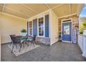 Relaxing outdoor covered porch with table, chairs, welcome sign, and stone accents at 1309 Suncrest Dr., Myrtle Beach, SC 29577