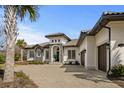Stunning home features a paved driveway, tiled roof, stone accents, and a grand entrance at 1549 Casita Ln., Myrtle Beach, SC 29579