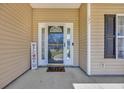 Inviting front porch with a decorative welcome sign and a storm door entry for added security and curb appeal at 171 Talon Dr., Conway, SC 29527