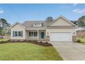 Inviting single-Gathering home showcasing manicured lawn, neutral siding, blue shutters, and a convenient attached garage at 198 Ford Rd., Pawleys Island, SC 29585