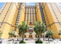 Beautiful low-angle shot of a yellow building with palm trees and clear blue sky at 2600 N Ocean Blvd. # 1914, Myrtle Beach, SC 29577