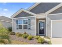 Up-close view of a charming home with a black front door, and well-maintained landscaping at 2848 Ophelia Way, Myrtle Beach, SC 29577