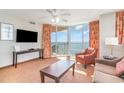 Cozy living room with ocean views, ceiling fan, TV, balcony access, and comfortable seating at 3500 N Ocean Blvd. # 902, North Myrtle Beach, SC 29582