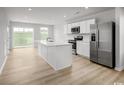 Open concept kitchen with stainless steel appliances, center island, and view of the adjacent dining area at 442 Myrtle Meadows Dr, Conway, SC 29526