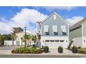 Beautiful exterior showcasing light blue siding, a white garage door, and well-maintained landscaping in a residential neighborhood at 512 9Th Ave. S, North Myrtle Beach, SC 29582