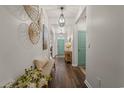 Inviting hallway with wood floors, stylish light fixtures, decor and a bright teal door at 515 Goldstar St., Conway, SC 29526
