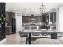Open-concept kitchen and dining area with modern lighting, dark cabinets, and stainless appliances at 5628 Camilla Ct., Myrtle Beach, SC 29579