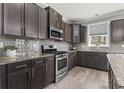 Stylish kitchen featuring dark cabinets, stainless steel appliances, and a gray tile backsplash at 5628 Camilla Ct., Myrtle Beach, SC 29579