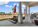 Welcoming front porch featuring rocking chairs, decorative flags, and manicured landscaping at 900 Pelagic Loop, Myrtle Beach, SC 29579