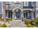 Close up of the front entrance with stone accents, iron railings, and mature landscaping at 900 Waterside St., North Myrtle Beach, SC 29582