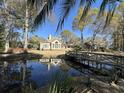 Lush backyard features pond, bridge, mature trees, and an inviting outdoor space, surrounded by nature at 1599 Hawthorn Dr., Pawleys Island, SC 29585