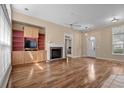 Bright living room featuring a brick fireplace, built-in shelves, and hardwood floors at 192 Berkshire Loop, Pawleys Island, SC 29585