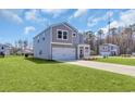 Charming two-story home with grey siding, two car garage, covered entry, and manicured lawn at 204 Leaflet Loop, Pawleys Island, SC 29585