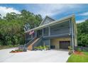 Beautiful exterior of a home with an American flag, large driveway, garage space and lovely landscaping at 224 Oak Bay Dr., Georgetown, SC 29440