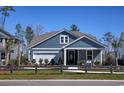 Charming single-Gathering home featuring a stylish blue exterior, manicured lawn, and welcoming front porch for relaxing outdoors at 3020 River Island Way, Myrtle Beach, SC 29588