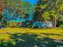 Spacious yard with green grass, mature trees, and a manufactured home at 3641 Half Pint Rd., Longs, SC 29568