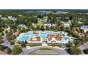 Aerial view showcases an elaborate community pool, surrounded by homes and green spaces at 390 Starlit Way, Myrtle Beach, SC 29579