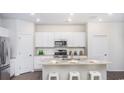 Modern kitchen features white cabinetry, stainless steel appliances and granite countertops at 407 Ladyfish Loop, Sunset Beach, NC 28468