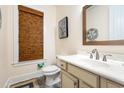 Cozy powder room featuring a sink with marble countertop, bronze faucet, and decorative mirror at 452 Banyan Place, North Myrtle Beach, SC 29582