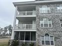 Condo building exterior with gray brick, light blue siding, and screened-in balconies at 4639 Wild Iris Dr. # 43-204, Myrtle Beach, SC 29577