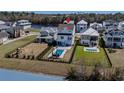 Aerial view of a home with a backyard pool, set near a tranquil lake and neighboring houses at 482 Harbour View Dr., Myrtle Beach, SC 29579