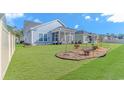 Spacious backyard featuring a well-maintained lawn, mulch garden, and a screened-in porch area at 6366 Chadderton Circle, Myrtle Beach, SC 29579