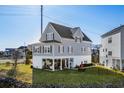 Charming two-story coastal home with a lush green lawn, covered patio, and lovely curb appeal at 100 Marblehead Dr., Little River, SC 29566