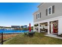 Relaxing outdoor patio with waterfront views, lounge seating, and red patio umbrella at 100 Marblehead Dr., Little River, SC 29566