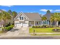 Inviting home with a cozy front porch, lush green lawn, and convenient two-car garage at 1127 East Isle Of Palms Ave., Myrtle Beach, SC 29579