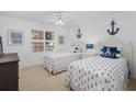 Charming bedroom with two twin beds, nautical decor, and ample natural light at 145 S Dunes Dr. # 109, Pawleys Island, SC 29585