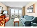 Cozy living room with sliding glass doors to a private balcony offering beautiful views at 161 Seawatch Dr. # 410, Myrtle Beach, SC 29572