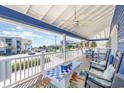 Relaxing covered porch featuring comfortable seating, a ceiling fan, and neighborhood views at 1644 South Waccamaw Dr., Murrells Inlet, SC 29576