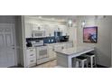 Modern kitchen with white cabinetry, updated appliances, and a breakfast bar with seating at 218 Double Eagle Dr., Surfside Beach, SC 29575