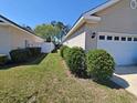 Clean side yard features healthy lawn, shrubbery, and a white fence for added privacy at 221 Black Bear Rd., Myrtle Beach, SC 29588
