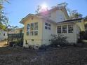 Back exterior showcasing sunroom, multiple windows, and a deck with green railings at 2240 Jackson Circle, Little River, SC 29566