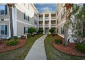 Exterior view of condo building with lush landscaping at 244 Sun Colony Blvd. # 102, Longs, SC 29568