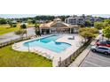 Resort-style pool and spa with surrounding lounge chairs and a covered clubhouse area at 395 S Crow Creek Dr. # 1708, Calabash, NC 28467