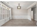 Elegant dining room with light wood floors, paneled walls, plantation shutters and modern light fixture at 4222 Congressional Dr., Myrtle Beach, SC 29579
