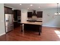 Modern kitchen featuring stainless steel appliances, a spacious island, and dark wood cabinets at 4437 Marshwood Dr., Myrtle Beach, SC 29579