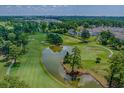 High aerial view of a golf course and pond, with lush green fairways surrounded by trees at 4709 Wild Iris Dr. # 305, Myrtle Beach, SC 29577