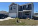 Inviting two-story home with a covered porch, neat landscaping, and attached two-car garage at 645 Black Pearl Way, Myrtle Beach, SC 29588