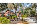 Beautiful brick home featuring manicured landscaping, a garden, and a spacious driveway at 74 Dornoch Dr., Pawleys Island, SC 29585