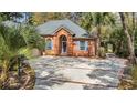 Attractive brick home featuring blue shutters, a circular driveway, and mature trees at 74 Dornoch Dr., Pawleys Island, SC 29585