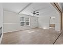 Living room with wood floors, white walls, ceiling fan, and large windows at 909 Pine Thicket St., Myrtle Beach, SC 29577