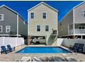 Backyard with a private pool surrounded by lounge chairs, a white fence and a well maintained yard at 113B 15Th Ave. S, Surfside Beach, SC 29575